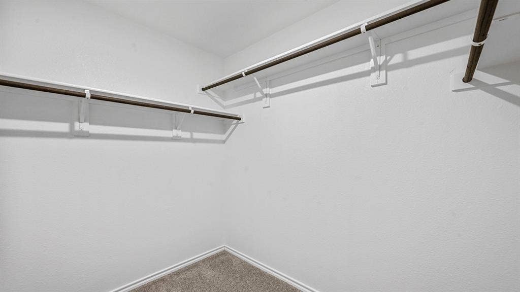 810 Parksville Drive, Ferris, TX 75125 Walk-in closet with ample storage, integrated shelving, and carpeted flooring