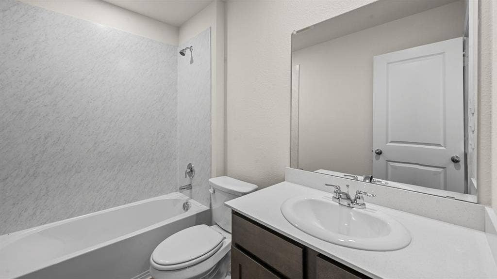 810 Parksville Drive, Ferris, TX 75125 Bathtub with shower, toilet, vanity with integrated sink, and wall-mounted mirror