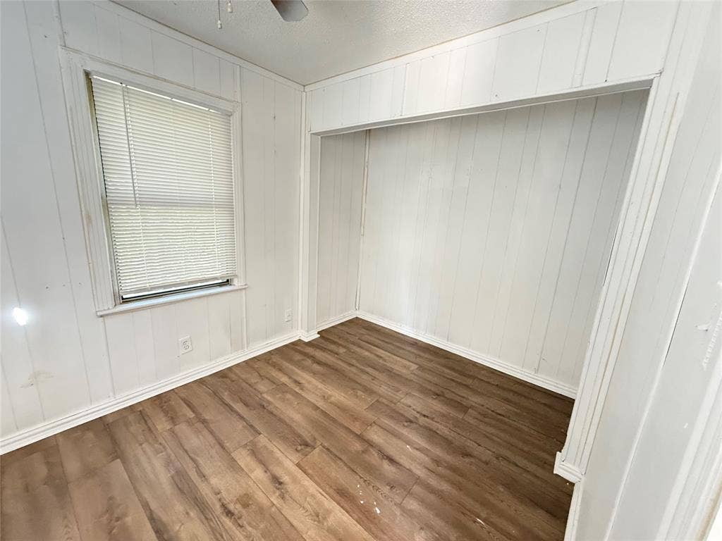 2952 Bardwell Avenue, Dallas, TX 75216 Wood-finish flooring, white paneled walls, and a recessed alcove