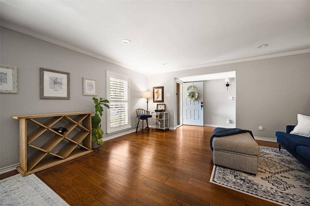 10945 Middle Knoll Drive, Dallas, TX 75238 Hardwood-style flooring throughout, light gray wall paint, plantation shutters, recessed ceiling lighting, and a light blue entry door