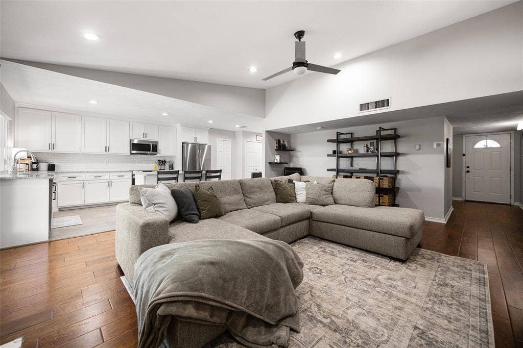 10945 Middle Knoll Drive, Dallas, TX 75238 Vaulted ceiling with a ceiling fan, recessed lighting, wood-finish flooring, white cabinetry, and stainless steel appliances