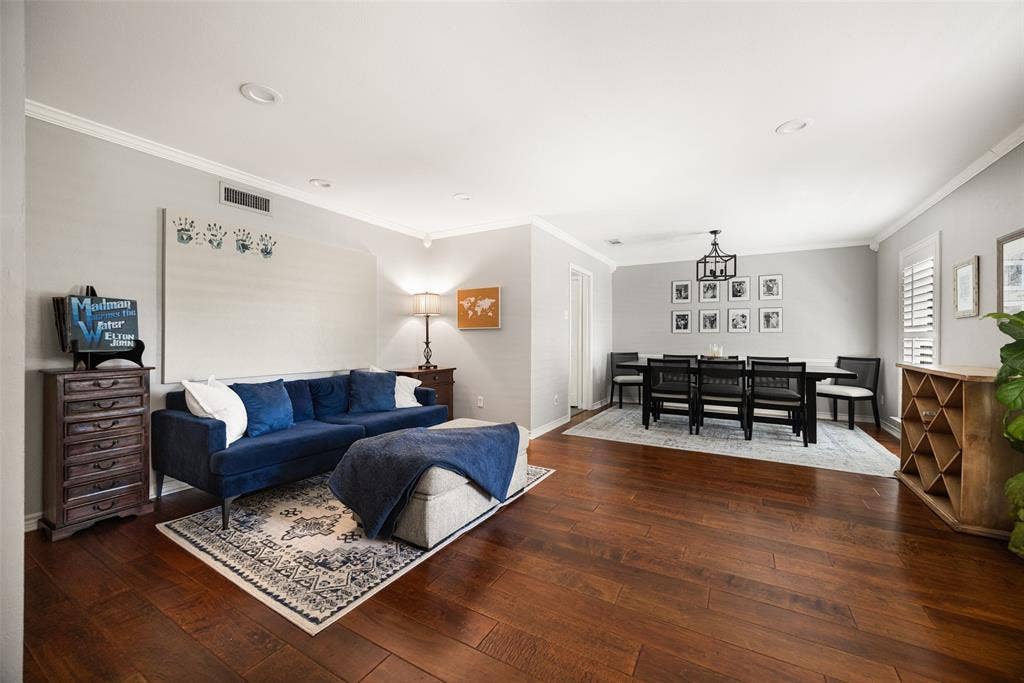 10945 Middle Knoll Drive, Dallas, TX 75238 Wood-finish flooring throughout, featuring crown molding, recessed lighting, and a defined dining area with a chandelier