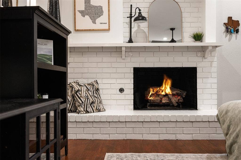 10945 Middle Knoll Drive, Dallas, TX 75238 White painted brick fireplace with a substantial hearth and mantel