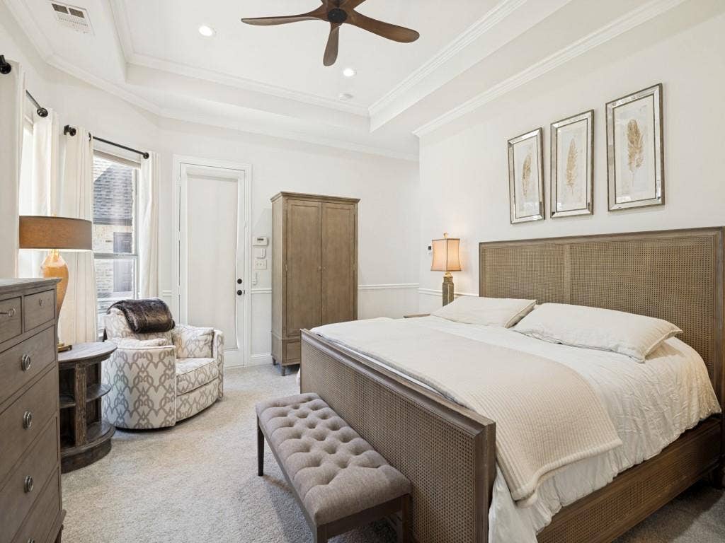The primary bedroom boasts recessed ceiling and lighting, crown molding, and gorgeous views of the back yard.