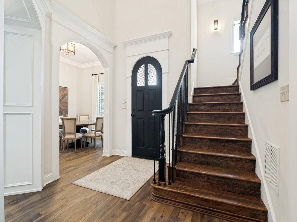 Custom arches and millwork grace the entry to the home.  The stairs are hand scraped wood which extends into the upstairs.