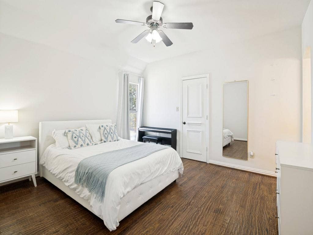 Large secondary bedroom upstairs with wood floor and walk-in closet.