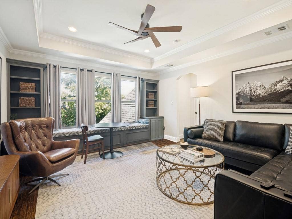 Large second level living area with wood floor, custom ceiling, recessed lighting and built-ins.