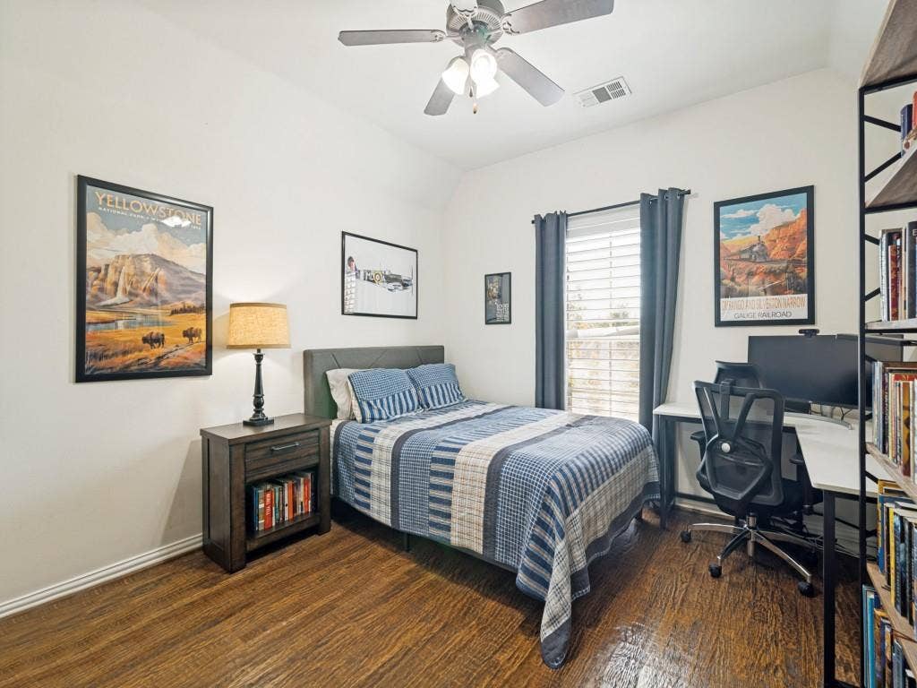 Upstairs secondary bedroom with wood floor and walk-in closet.