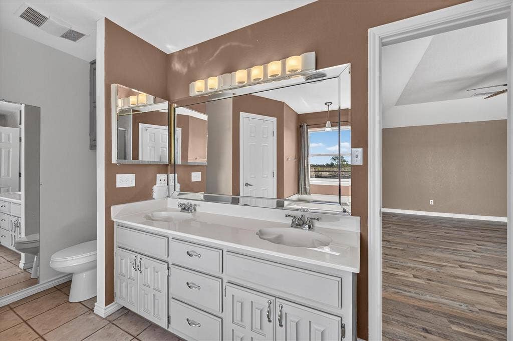 Dual vanity with white cabinetry, integrated sinks, and polished chrome faucets