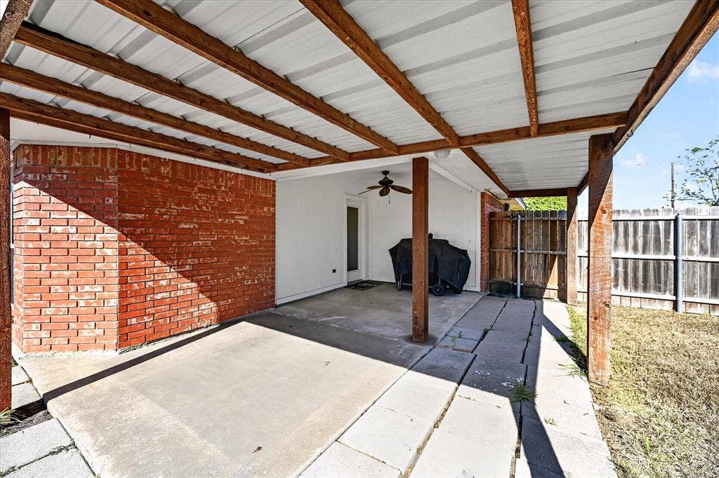 Covered patio featuring a metal roof, exposed wood beams, and a ceiling fan