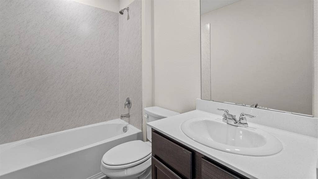 189 Brooks Street, Bullard, TX 75757 Built-in bathtub with a shower fixture, wall-mounted vanity mirror, and an undermount sink with a chrome faucet