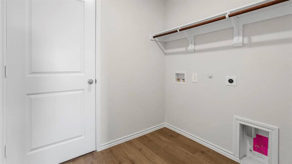 189 Brooks Street, Bullard, TX 75757 Laundry area featuring wood-finish flooring, white walls, and a built-in hanging rod with shelving