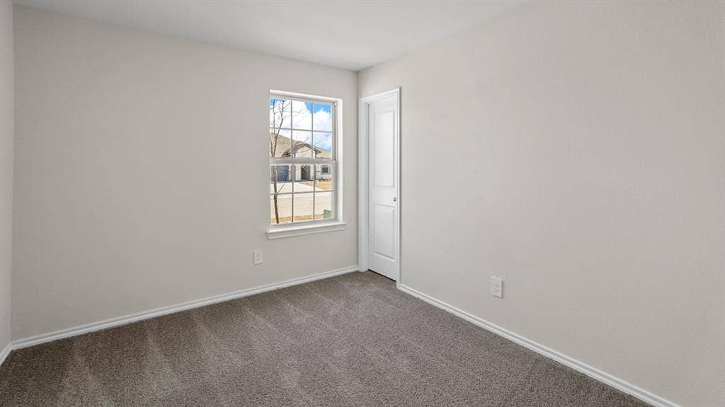 189 Brooks Street, Bullard, TX 75757 Neutral tone wall finishes, gray carpeting, white trim, and a paneled interior door