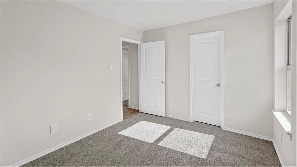 189 Brooks Street, Bullard, TX 75757 Light gray walls with white trim, gray carpet flooring, and two white panel doors