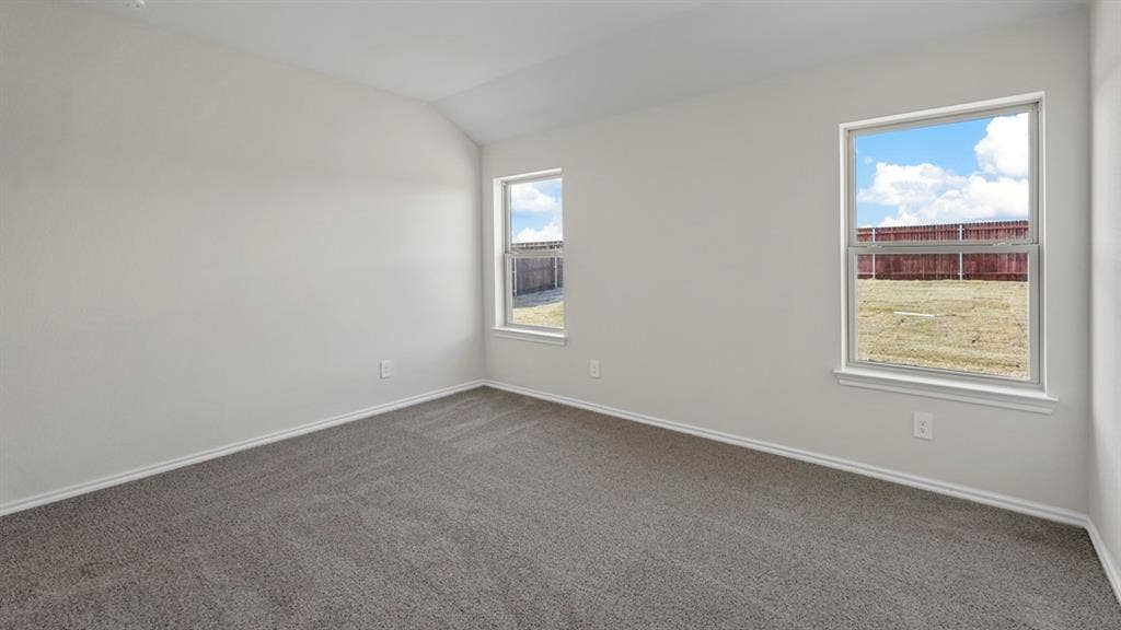 189 Brooks Street, Bullard, TX 75757 Carpeted room featuring white walls, vaulted ceiling, and dual windows