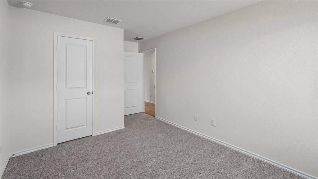 215 Yates Street, Bullard, TX 75757 Neutral toned walls with textured finish, gray carpet flooring, and white interior doors
