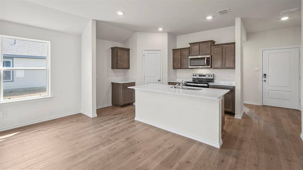 215 Yates Street, Bullard, TX 75757 Open-concept living space with wood-finish flooring, recessed lighting, and vaulted ceilings