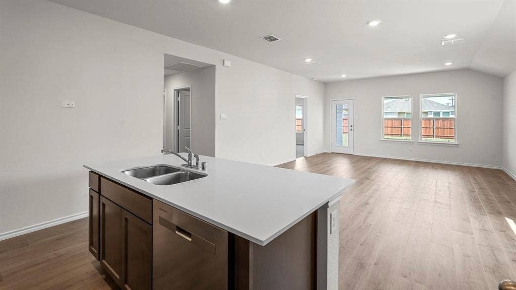 215 Yates Street, Bullard, TX 75757 Kitchen island with a double basin sink, light-toned countertop, and integrated dishwasher