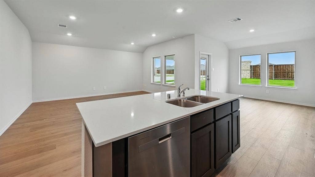 209 Yates Street, Bullard, TX 75757 Kitchen island with a white countertop and dark cabinetry, stainless steel dishwasher, and a double basin sink