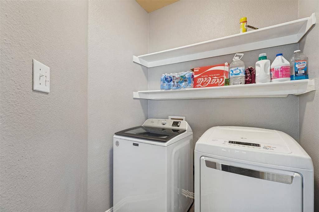 Laundry area with white upper shelving
