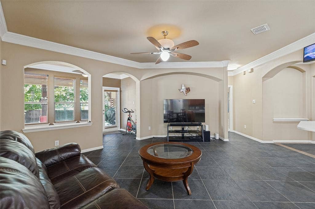 Archways, crown molding, a ceiling fan, and looking in to sun room
