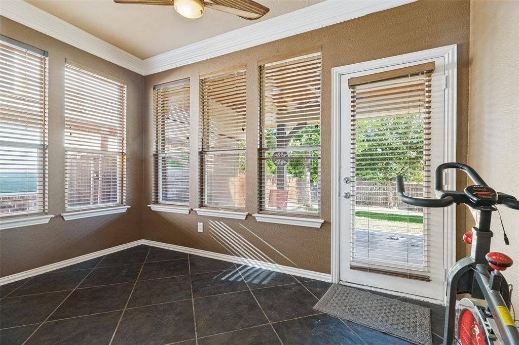 Light filled sunroom with crown molding looking to back yard