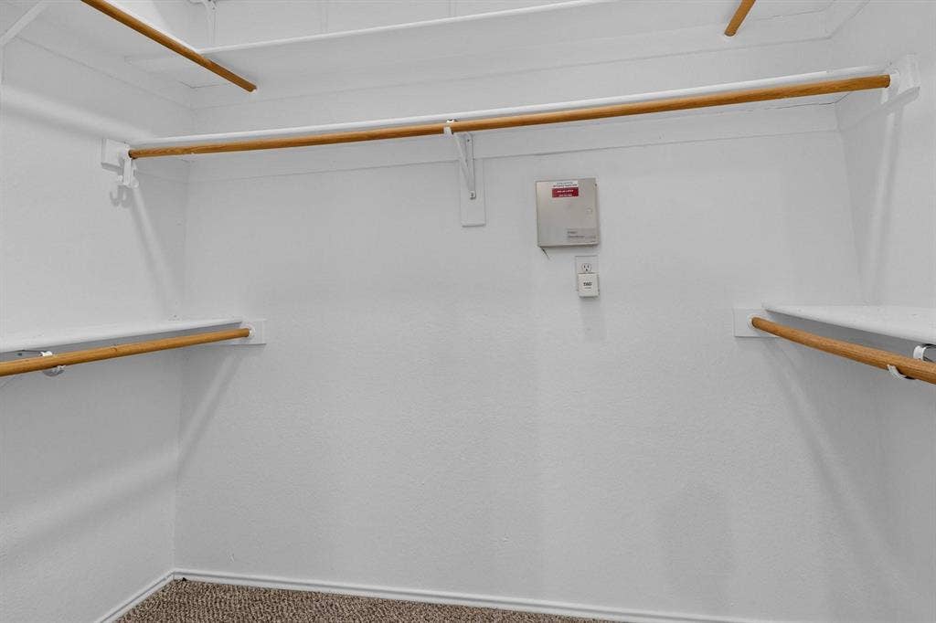 2702 Garden Springs Drive, Richardson, TX 75082 Built-in shelving and hanging rods with a carpeted floor