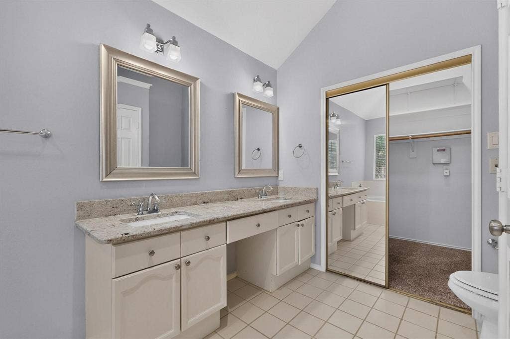 2702 Garden Springs Drive, Richardson, TX 75082 Dual vanity with light-toned countertop, framed mirrors, and chrome fixtures