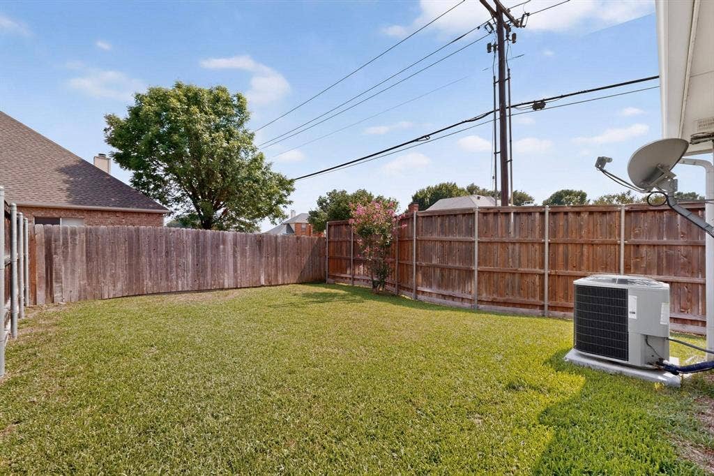 2702 Garden Springs Drive, Richardson, TX 75082 Grassed backyard featuring a wood fence perimeter and mature trees