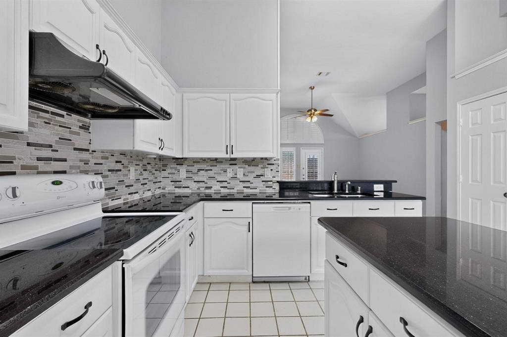 2702 Garden Springs Drive, Richardson, TX 75082 Kitchen featuring white cabinetry, black countertops, tile flooring, a tile backsplash, and white appliances