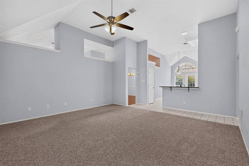 2702 Garden Springs Drive, Richardson, TX 75082 Vaulted ceilings, contemporary ceiling fan, carpet flooring, a breakfast bar with an overhanging countertop, and a tiled entry