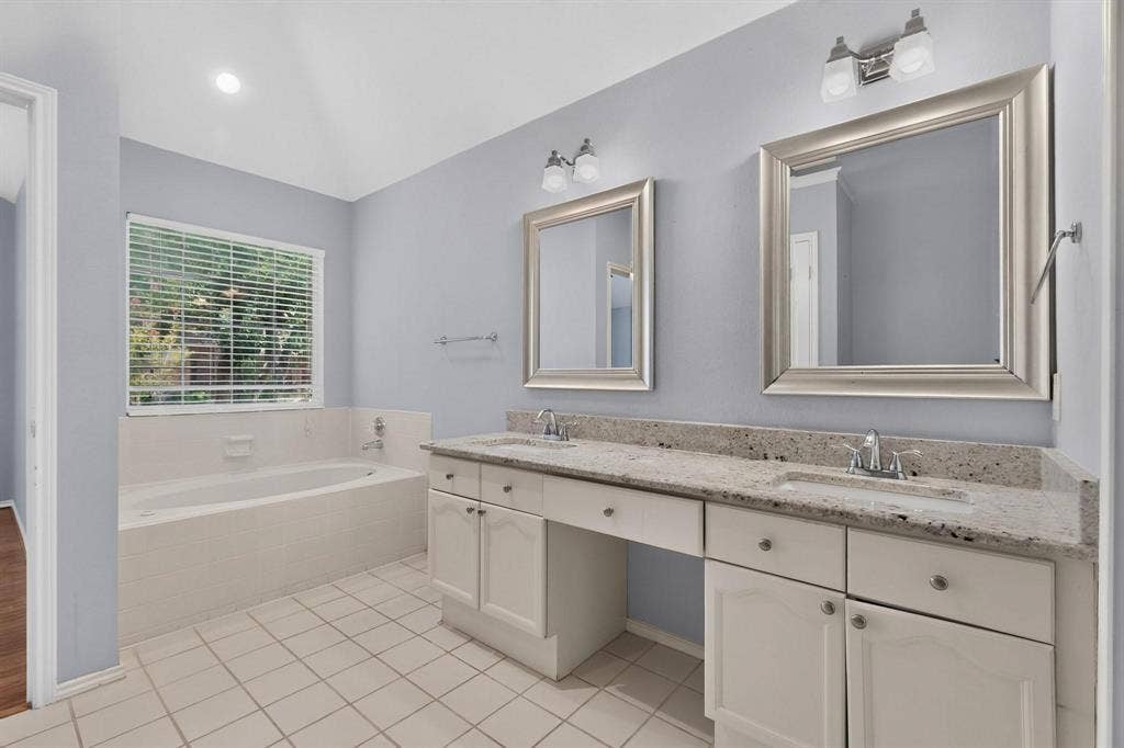 2702 Garden Springs Drive, Richardson, TX 75082 Dual vanity with stone-finish countertop, framed mirrors, undermount sinks, and built-in cabinetry
