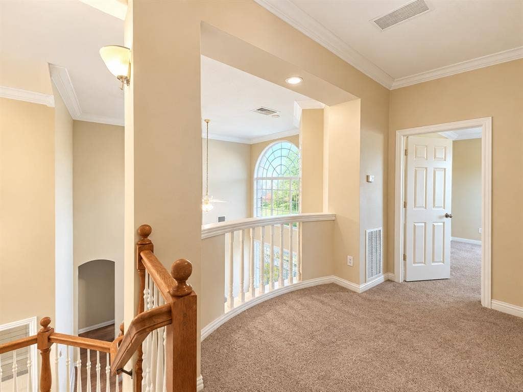 10316 Donley Drive, Irving, TX 75063 Carpeted loft area featuring a curved railing, a paneled interior door, and crown molding