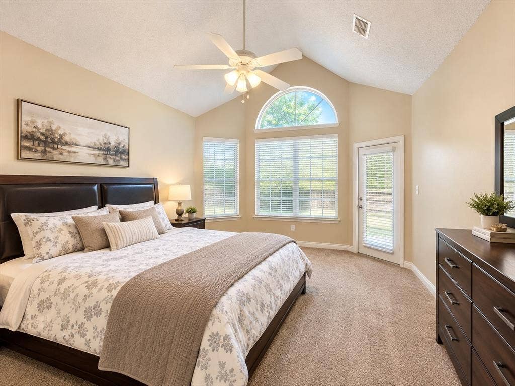 10316 Donley Drive, Irving, TX 75063 Vaulted ceiling with ceiling fan, arched transom window, glass-paned exterior door, and carpet flooring
