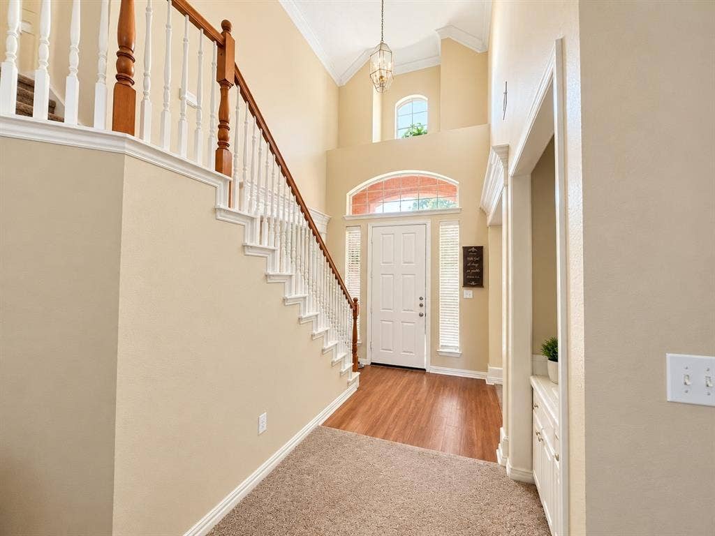 10316 Donley Drive, Irving, TX 75063 Two-story foyer with a vaulted ceiling, wood-finish flooring, and a white paneled entry door with sidelights