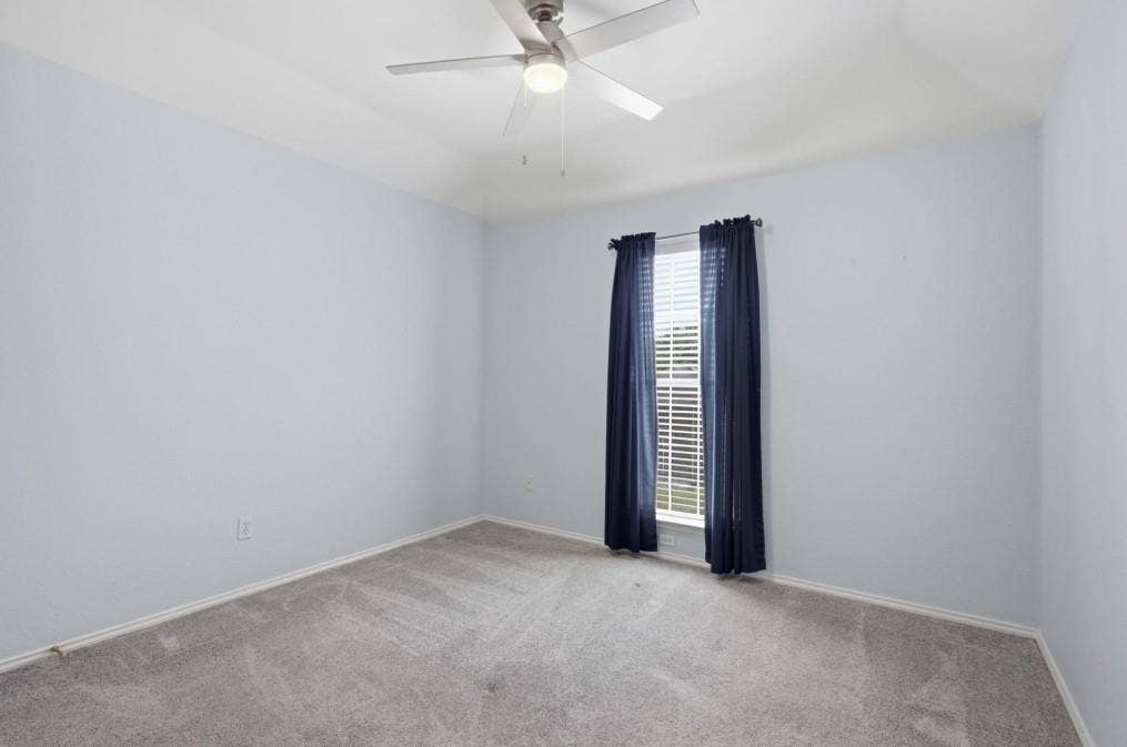 Recessed window featuring blinds, light gray wall finish, and gray carpet flooring