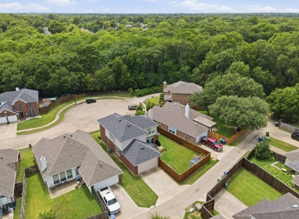 Aerial perspective of a cul-de-sac community featuring multiple residential properties with pitched roofs and attached garages