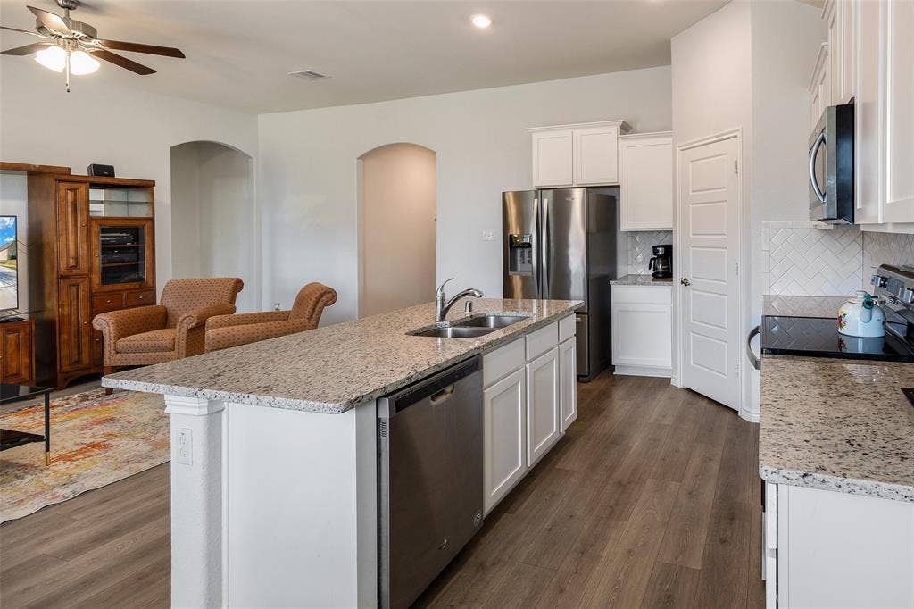 1101 Crepe Myrtle Lane, Anna, TX 75409 Kitchen featuring white cabinetry, granite countertops, wood-finish flooring, and stainless steel appliances
