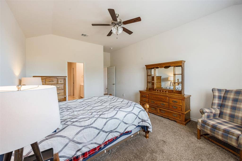1101 Crepe Myrtle Lane, Anna, TX 75409 Vaulted ceiling with a ceiling fan, carpeted flooring, and a doorway leading to an additional space