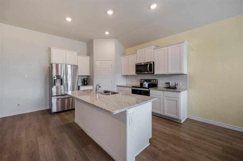 1101 Crepe Myrtle Lane, Anna, TX 75409 Kitchen featuring wood-finish flooring, recessed lighting, white cabinetry, a kitchen island with sink, and stainless steel appliances