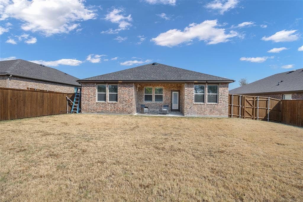 1101 Crepe Myrtle Lane, Anna, TX 75409 Brick exterior with a dark-shingle roof, offering a rear patio area