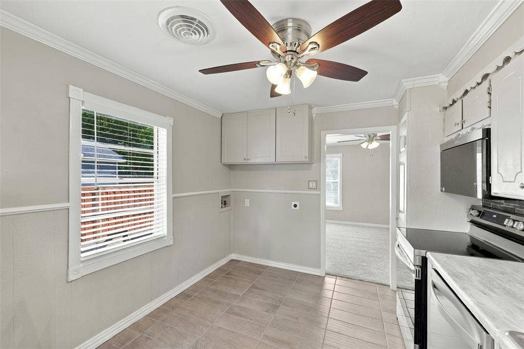 605 NE 33rd Street, Grand Prairie, TX 75050 Kitchen featuring tile flooring, white cabinetry, stainless steel microwave, and a ceiling fan with integrated lighting