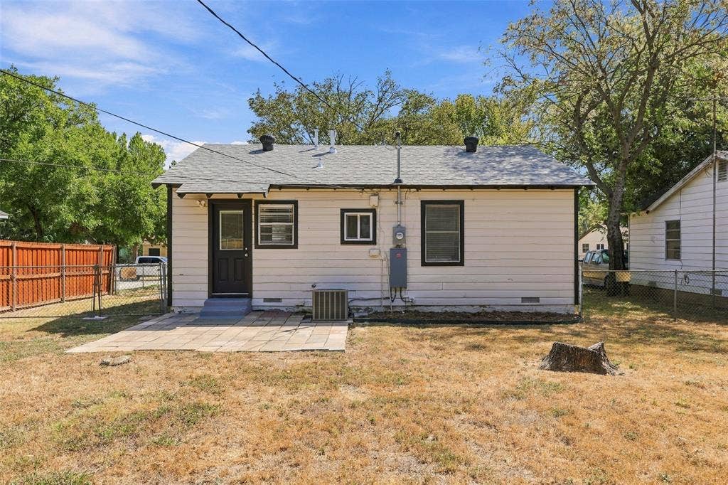 605 NE 33rd Street, Grand Prairie, TX 75050 Rear exterior with a paved patio area and white siding