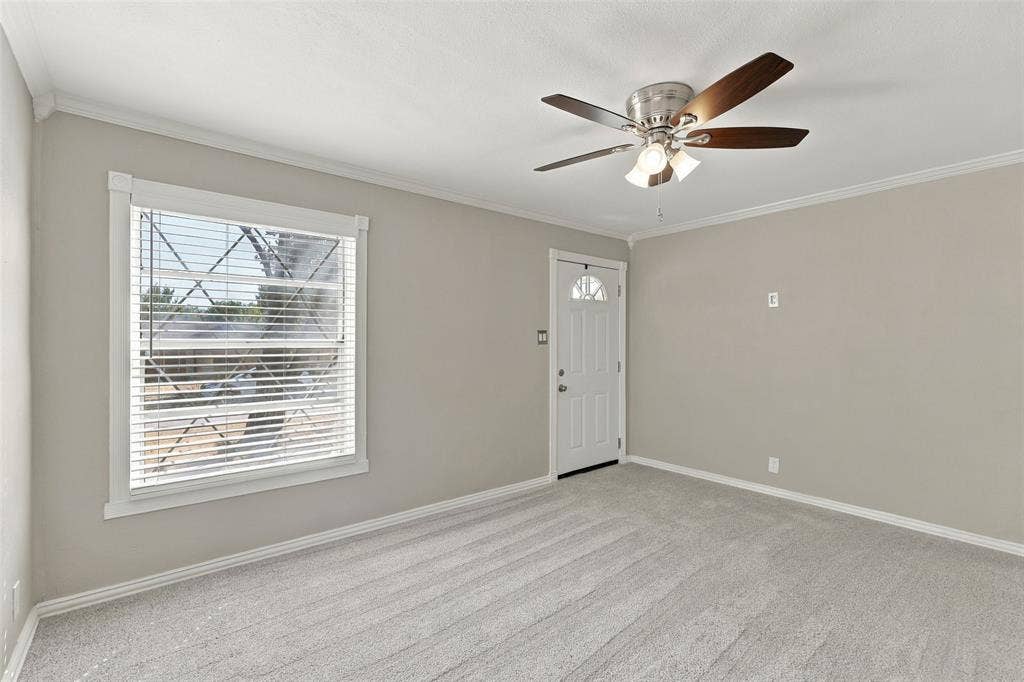605 NE 33rd Street, Grand Prairie, TX 75050 Light gray wall paint, white trim, light gray carpeting, and a ceiling fan with light fixture