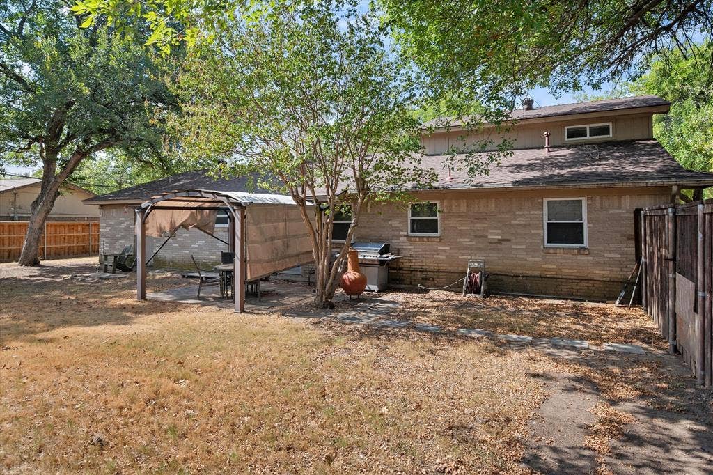 144 Jill Ann Drive, Burleson, TX 76028 Brick exterior featuring multiple windows and a dormer