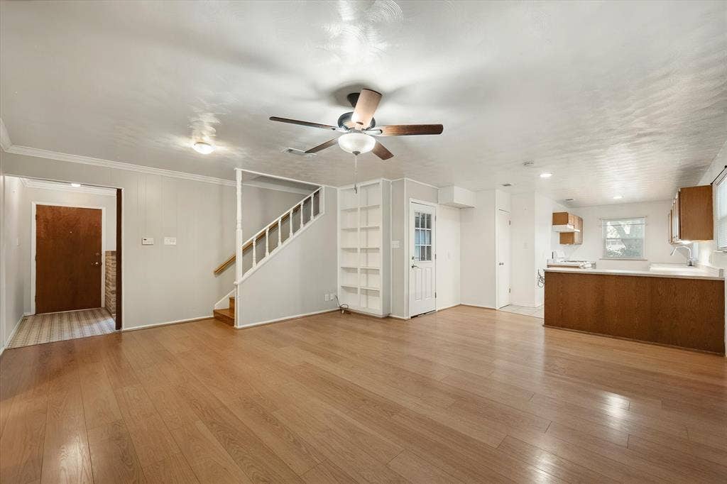 144 Jill Ann Drive, Burleson, TX 76028 Wood-finish flooring, ceiling fan with integrated lighting, built-in shelving, staircase with white risers, and a kitchen featuring wood cabinetry