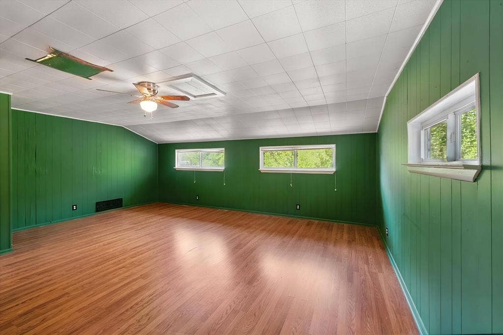 144 Jill Ann Drive, Burleson, TX 76028 Wood-finish flooring, paneled walls, ceiling fan with integrated lighting, and multiple windows