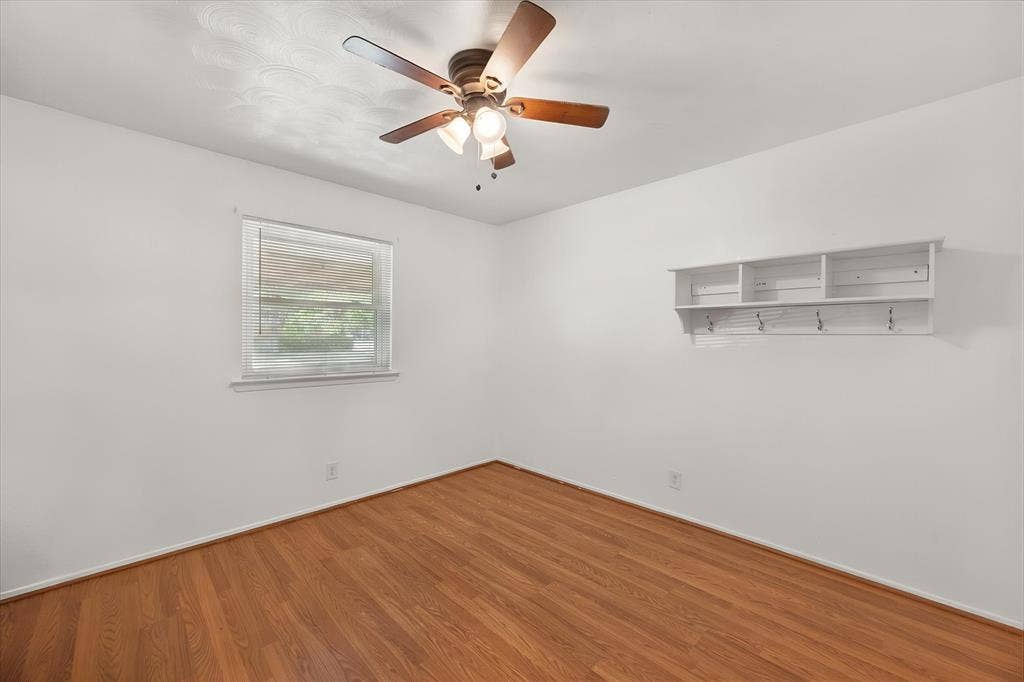 144 Jill Ann Drive, Burleson, TX 76028 Wood-finish flooring throughout, white walls, built-in shelving with hooks, and a ceiling fan with light fixture