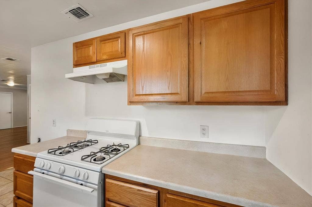 144 Jill Ann Drive, Burleson, TX 76028 White gas range with a matching range hood