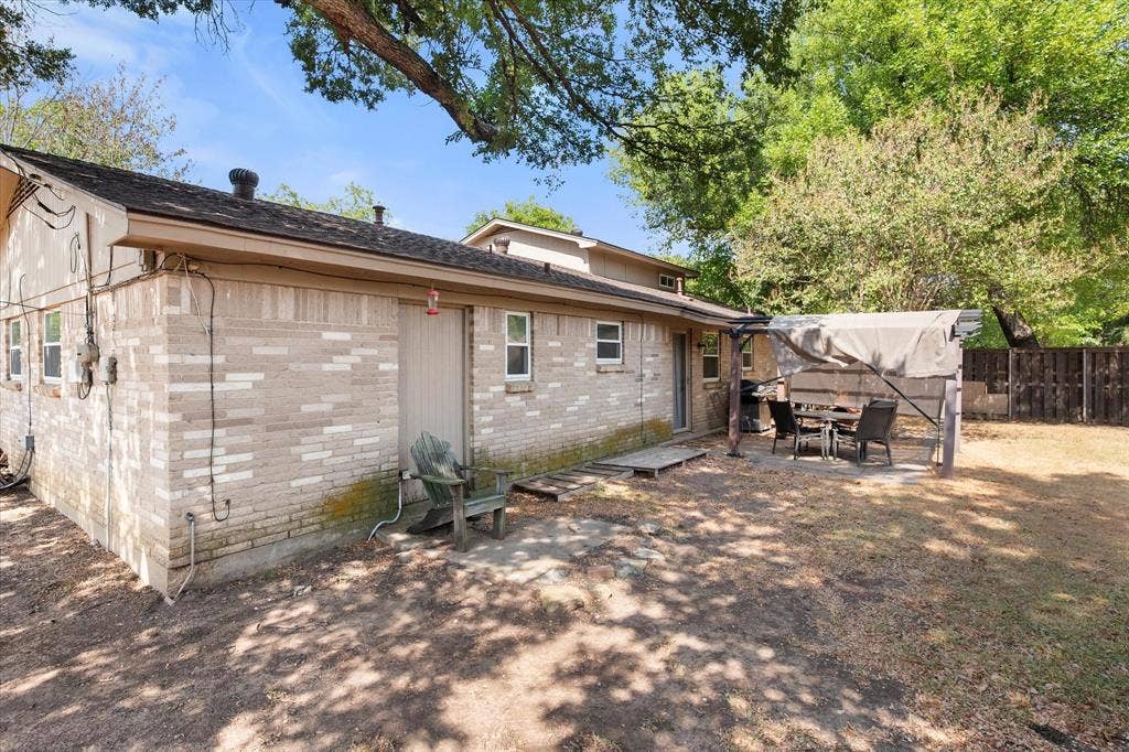 144 Jill Ann Drive, Burleson, TX 76028 Brick exterior, multiple windows, covered patio area, partial privacy fencing, mature trees